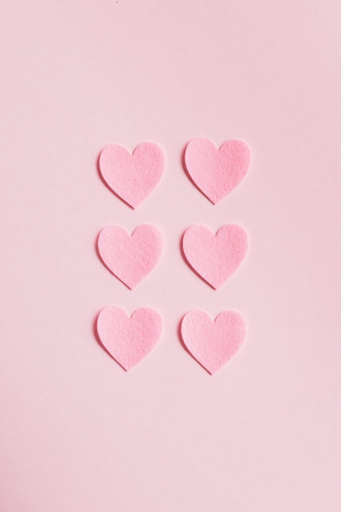 6 pink felt hearts on a pink background